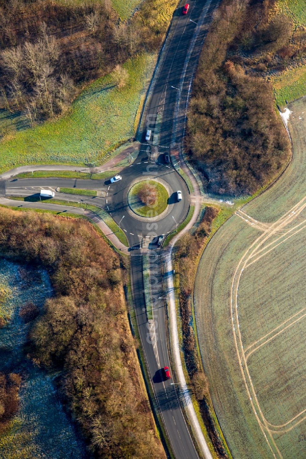 Aerial photograph Hamm - Traffic management of the roundabout road Sachsenring und Bernhard-Droste-Weg next to a grain Field with trees casting long shadows in autumnal Hamm in the state North Rhine-Westphalia