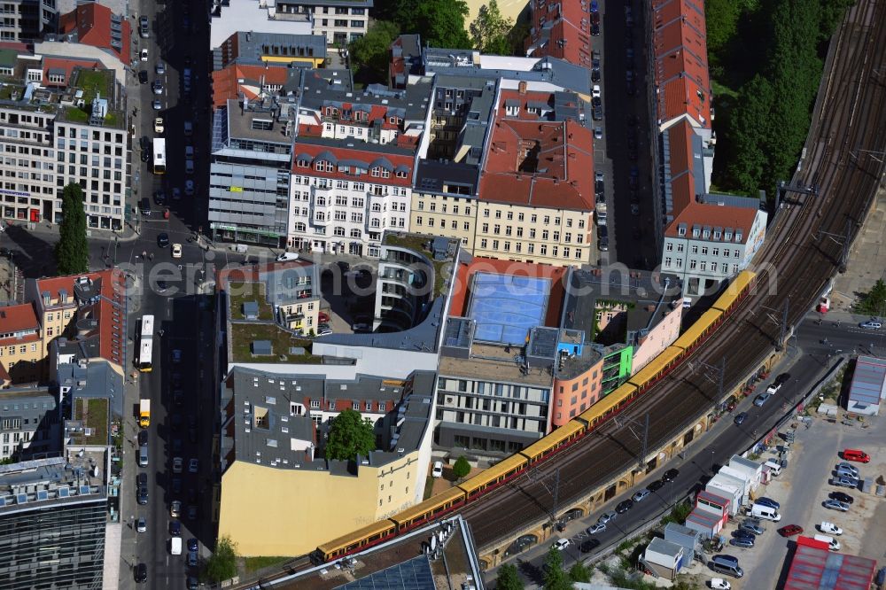 Aerial photograph Berlin - The train tracks run in an arc about the Luis Road and Reinhardt street in the Mitte district of Berlin. In the crossing region of the two roads is the Karlsplatz, where the poplar stands, which described Bertold Brecht in a poem. The Representation of the State Saxony-Anhlat has its headquarters in the Luis Street. To the right can stay in uniquely designed rooms at Arte Luise art hotel tourists. Striking is also the office and residential building with the C-shaped plan, which was designed by the architect Kapmann and partners