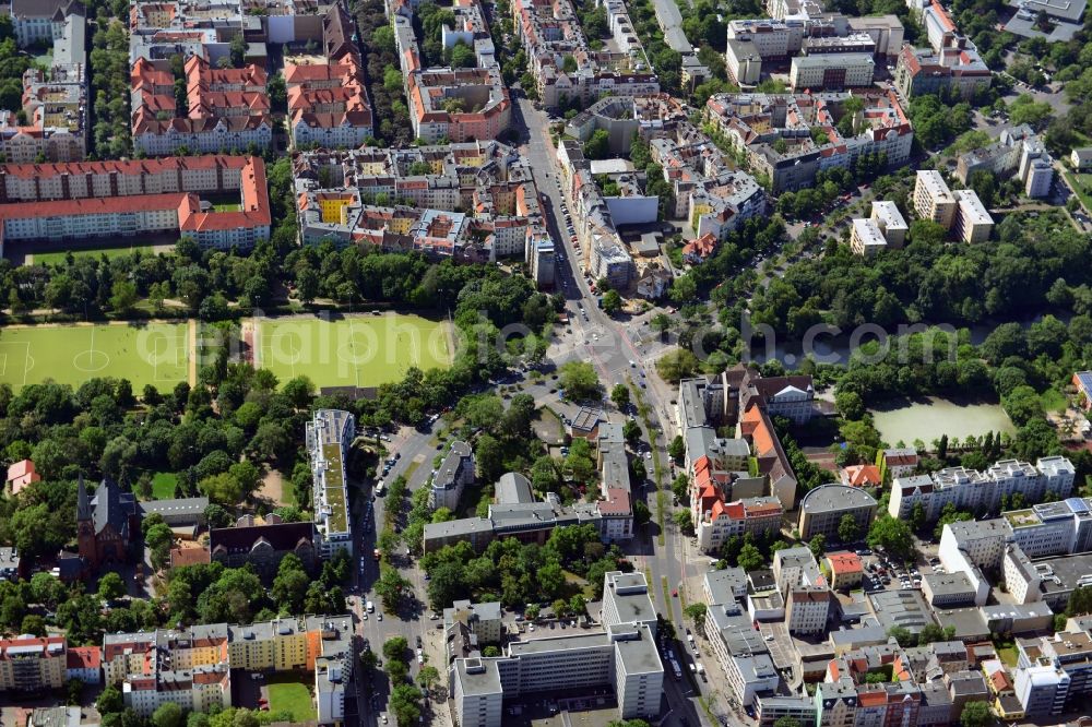 Aerial photograph Berlin - At the major intersection Blissestrasse - Uhland-street in the Wilmersdorf district of Berlin, the urban green space is - public park Wilmersdorf cut into two parts. The eastern part is here marked by two sports fields, which are used by 1.FC Wilmersdorf. In extending the western side of the public park, we see the lake Fennsee which is of natural origin. In the environment of the park Residential areas are located. There are two schools on the road Wilhelmsaue - the Friedrich-Ebert high school and the Comenius - school, which is right next to the Auenkirche