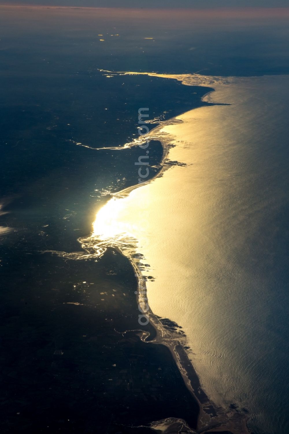 Maupertus-sur-Mer from the bird's eye view: Coastline on the sandy beach of English Channel in Maupertus-sur-Mer in Frankreich. The last rays of Sun- light reflect on the surface of the sea