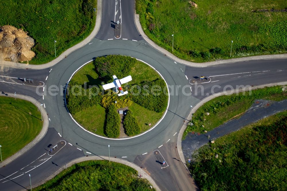 Burbach from above - Outdoor art- installation of a small aircraft on a traffic island of a roundabout at the airport Flughafen Siegerland in Burbach in the state North Rhine-Westphalia