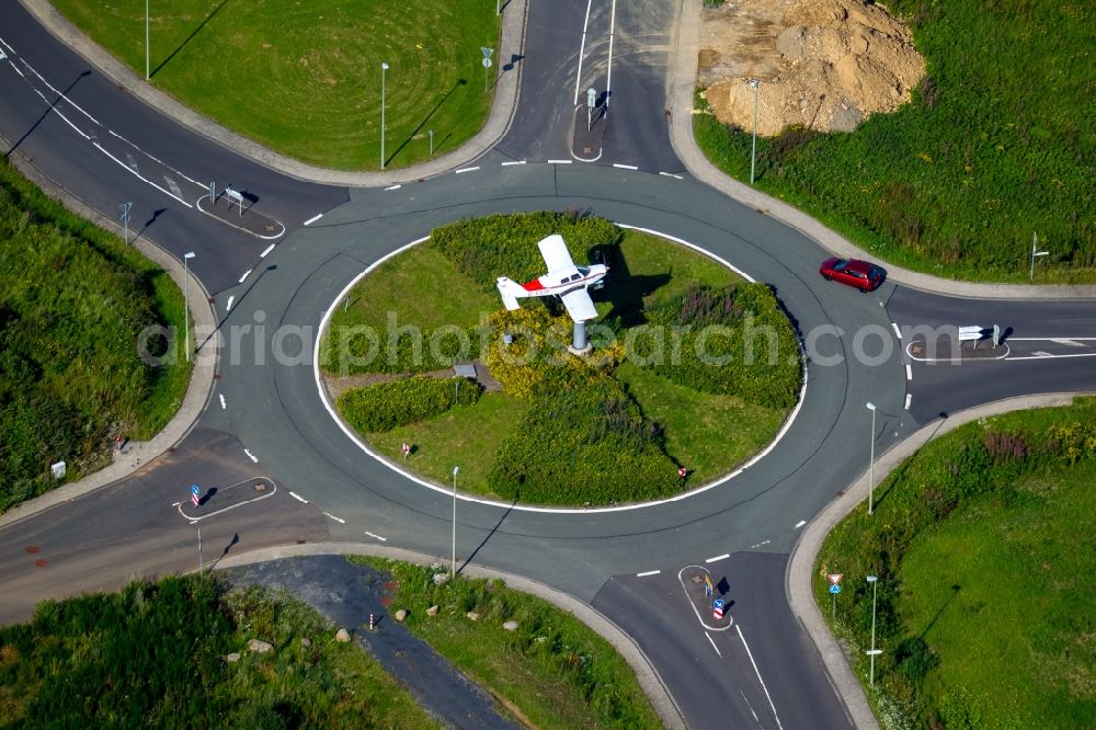 Burbach from the bird's eye view: Outdoor art- installation of a small aircraft on a traffic island of a roundabout at the airport Flughafen Siegerland in Burbach in the state North Rhine-Westphalia