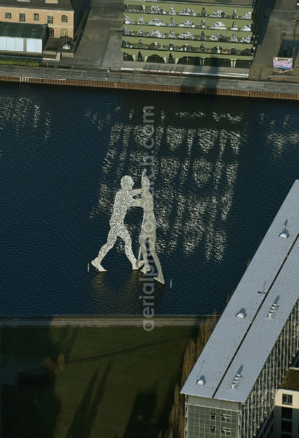 Berlin from the bird's eye view: Outdoor art- installation Molecule Man am Ufer des Flussverlaufes der Spree An den Treptowers in Berlin in Germany