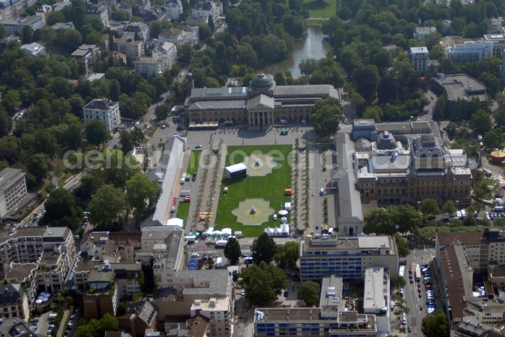 Wiesbaden from the bird's eye view: Blick auf den Kurhausplatz Bowling Green in Wiesbaden. Das Bowling Green ist eine Grünanlage in der hessischen Landeshauptstadt Wiesbaden. Die Bezeichnung Bowling Green stammt angeblich von englischen Kurgästen aus dem 19. Jh., die den Rasen mit einem englischen Ballspielplatz verglichen (Bowle). Das Bowling Green wird wegen seiner beeindruckenden Kulisse oft für Open-Air-Veranstaltungen genutzt. So fanden hier beispielsweise schon des Öfteren Konzerte statt. An den Platz grenzen: Das Kurhaus Wiesbaden und das Hessische Staatstheater Wiesbaden so unter an derem die Spielbank Wiesbaden im Kurhaus.