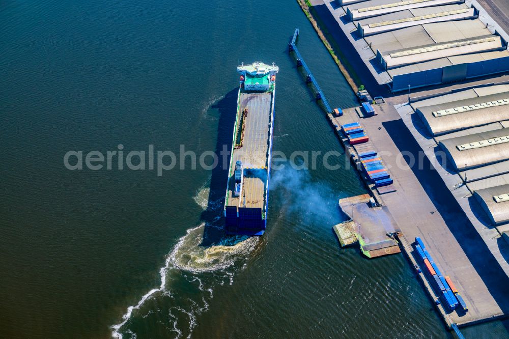 Lübeck from above - Warehouse complex building in the commercial area on the banks of the Trave with the car ferry Corona Sea on Fabrikstrasse in Luebeck in the state Schleswig-Holstein