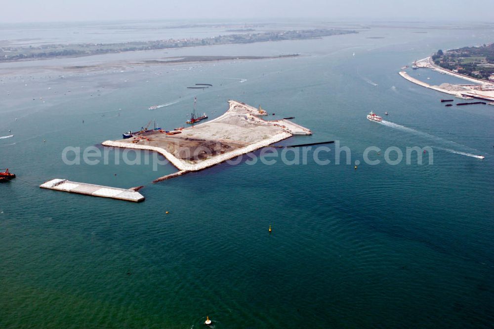 Venedig from the bird's eye view: Blick auf die Baustelle des Projekts M.O.S.E. bei Punta Sabbioni in Venedig. Die Abkürzung M.O.S.E. steht für modulo sperimentale eletromeccanico und bezeichnet ein bewegliches Flutschutzwehr. Das Sperrwerk soll besonders die historische Altstadt Venedigs vor Überflutungen schützen. Die Bauarbeiten begannen 2003. Umgesetzt wird das Projekt von der Firmengemeinschaft Consorzio Venezia Nuova, einem Zusammenschluss der 30 größten Baufirmen Italiens. View to the building area of the project M.O.S.E. near Punta Sabbioni in Venedig. The abbrevation M.O.S.E. stands for modulo sperimentale eletromeccanico and describes an moveable flood protection weir. The barrage should protect espacially the historic city of Venedig from flood. the construction work started in 2003. The project is realised from the company group Consorzio Venezia Nuova, wich is an union of the 30 largest building companys in italy.