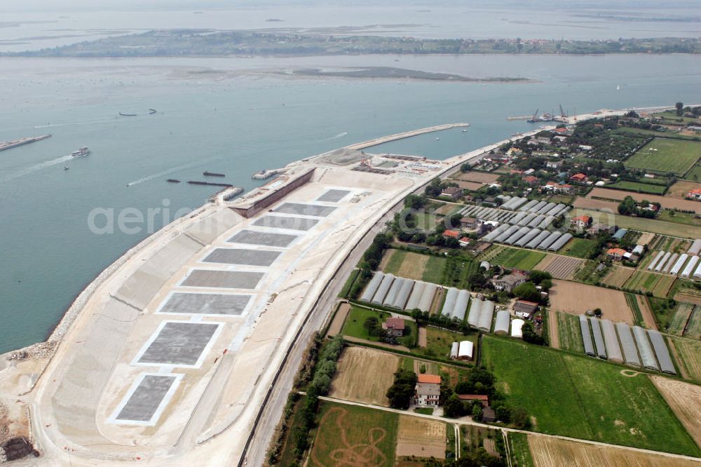 Aerial photograph Venedig - Blick auf die Baustelle des Projekts M.O.S.E. bei Punta Sabbioni in Venedig. Die Abkürzung M.O.S.E. steht für modulo sperimentale eletromeccanico und bezeichnet ein bewegliches Flutschutzwehr. Das Sperrwerk soll besonders die historische Altstadt Venedigs vor Überflutungen schützen. Die Bauarbeiten begannen 2003. Umgesetzt wird das Projekt von der Firmengemeinschaft Consorzio Venezia Nuova, einem Zusammenschluss der 30 größten Baufirmen Italiens. View to the building area of the project M.O.S.E. near Punta Sabbioni in Venedig. The abbrevation M.O.S.E. stands for modulo sperimentale eletromeccanico and describes an moveable flood protection weir. The barrage should protect espacially the historic city of Venedig from flood. the construction work started in 2003. The project is realised from the company group Consorzio Venezia Nuova, wich is an union of the 30 largest building companys in italy.