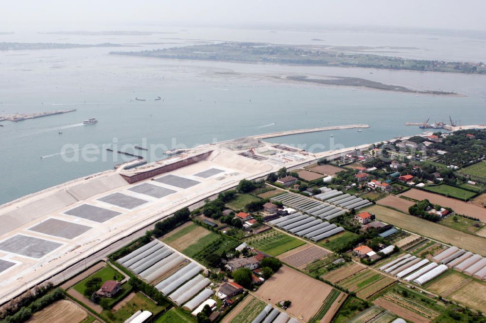 Venedig from above - Blick auf die Baustelle des Projekts M.O.S.E. bei Punta Sabbioni in Venedig. Die Abkürzung M.O.S.E. steht für modulo sperimentale eletromeccanico und bezeichnet ein bewegliches Flutschutzwehr. Das Sperrwerk soll besonders die historische Altstadt Venedigs vor Überflutungen schützen. Die Bauarbeiten begannen 2003. Umgesetzt wird das Projekt von der Firmengemeinschaft Consorzio Venezia Nuova, einem Zusammenschluss der 30 größten Baufirmen Italiens. View to the building area of the project M.O.S.E. near Punta Sabbioni in Venedig. The abbrevation M.O.S.E. stands for modulo sperimentale eletromeccanico and describes an moveable flood protection weir. The barrage should protect espacially the historic city of Venedig from flood. the construction work started in 2003. The project is realised from the company group Consorzio Venezia Nuova, wich is an union of the 30 largest building companys in italy.