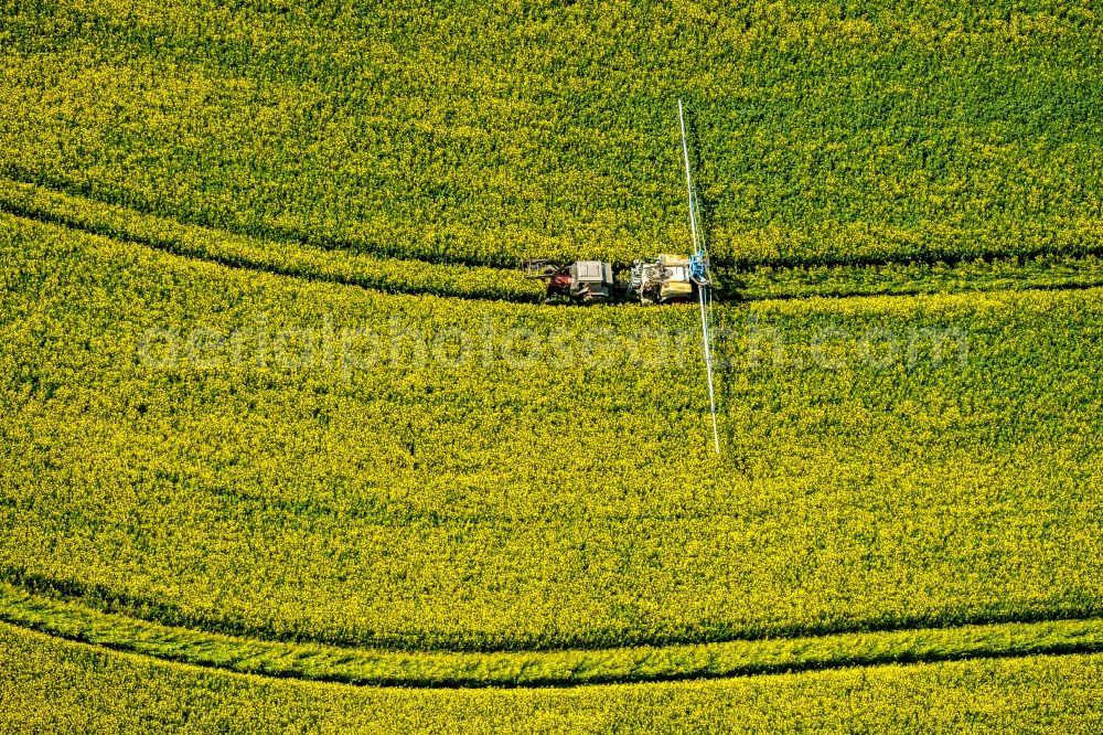 Aerial photograph Uelde - Farm equipment used for fertilizing yellow fields in Uelde in the state North Rhine-Westphalia, Germany