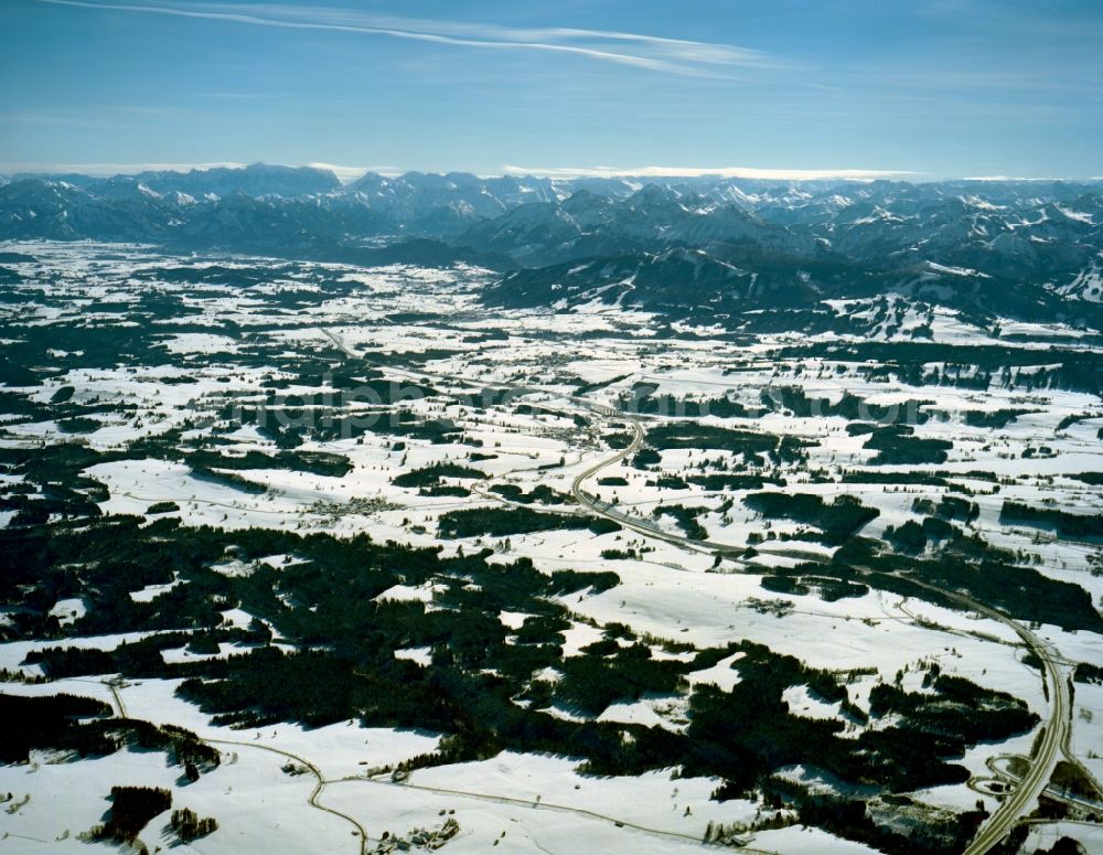 Kempten from above - Landscape and Alps around Kempten in the Allgäu region of the state of Bavaria. Visible in the background are the Alps and their mountain tops. The city and its outskirts are snow covered in the foreground