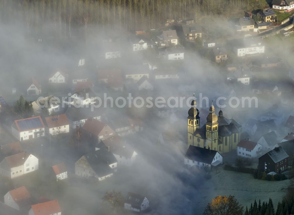 Marsberg OT Padberg from the bird's eye view: From fog layer and clouds outstanding Church of St. Mary Magdalene - also Padberger Dom-in Padberg, a district of Marsberg in North Rhine-Westphalia