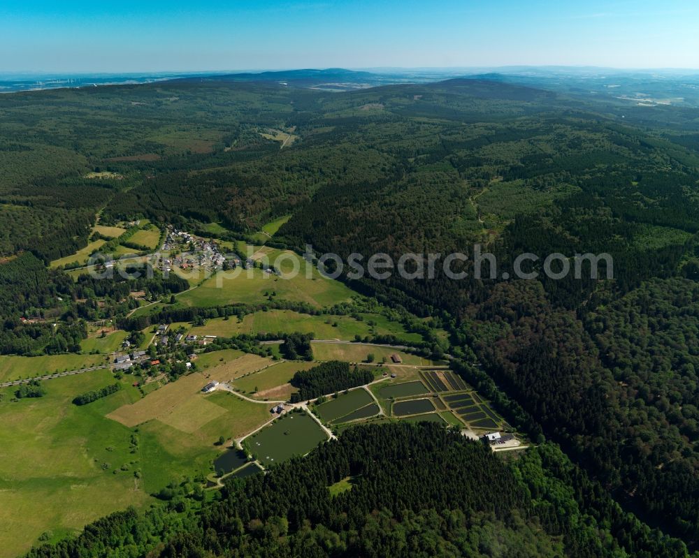 Börfink from above - View of the landscape around Boerfink in the state of Rhineland-Palatinate. The borough and municipiality is located in the county district of Birkenfeld, on Traunbach creek near the Erbeskopf mountain in the Hunsrueck region. It is surrounded by agricultural land, meadows and forest and consists of three hamlets: Einschiederhof, Forellenhof Trauntal and Thranenweier