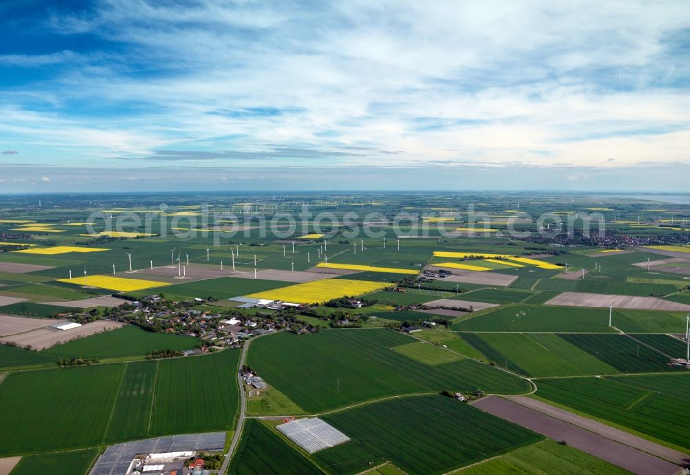 Warwerort from above - Landscape and panoramic view of the borough of Warwerort in the state of Schleswig-Holstein. The region is characterised by agricultural areas like canola fields, windmills and small villages. View to the North