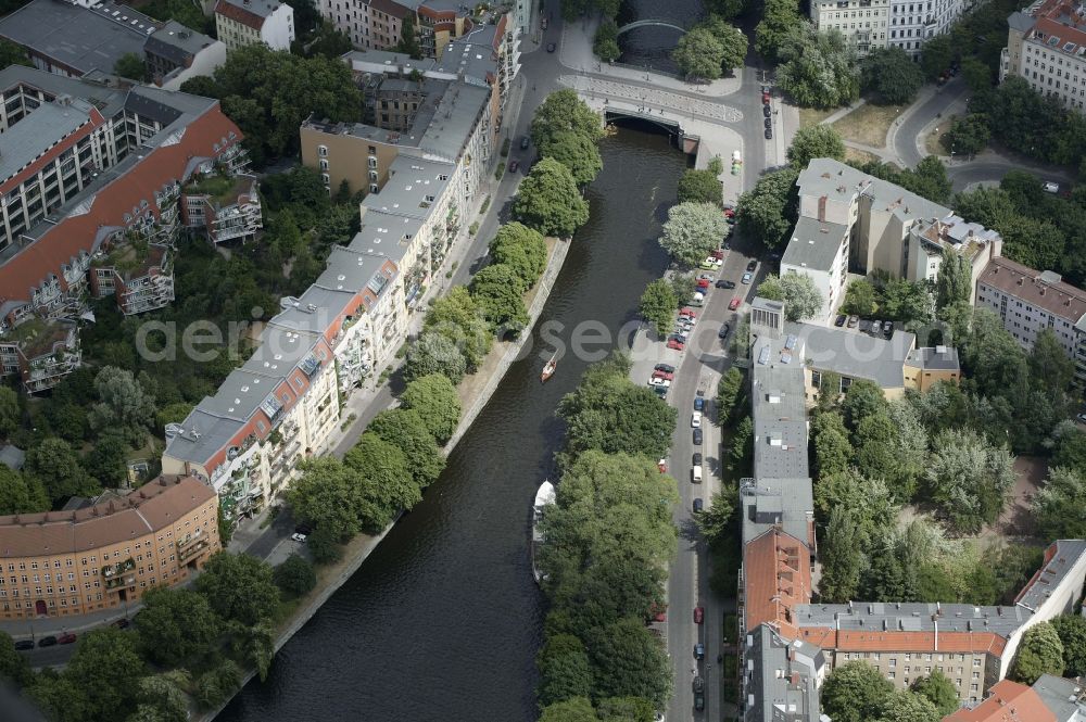 Aerial photograph Berlin - The Admiral bridge crosses in the Kreuzberg district of Berlin in Germany Berlin Landwehr Canal. The artificial waterway was created as a transport for heavy and bulky goods through the densely built residential quarters of the period. Today, the homes along the canal are coveted addresses. On the canal operate primarily the excursion boats and dinghies. The wrought iron bridge is a monument. The Admiral bridge is a popular attraction in the trendy district of Kreuzberg