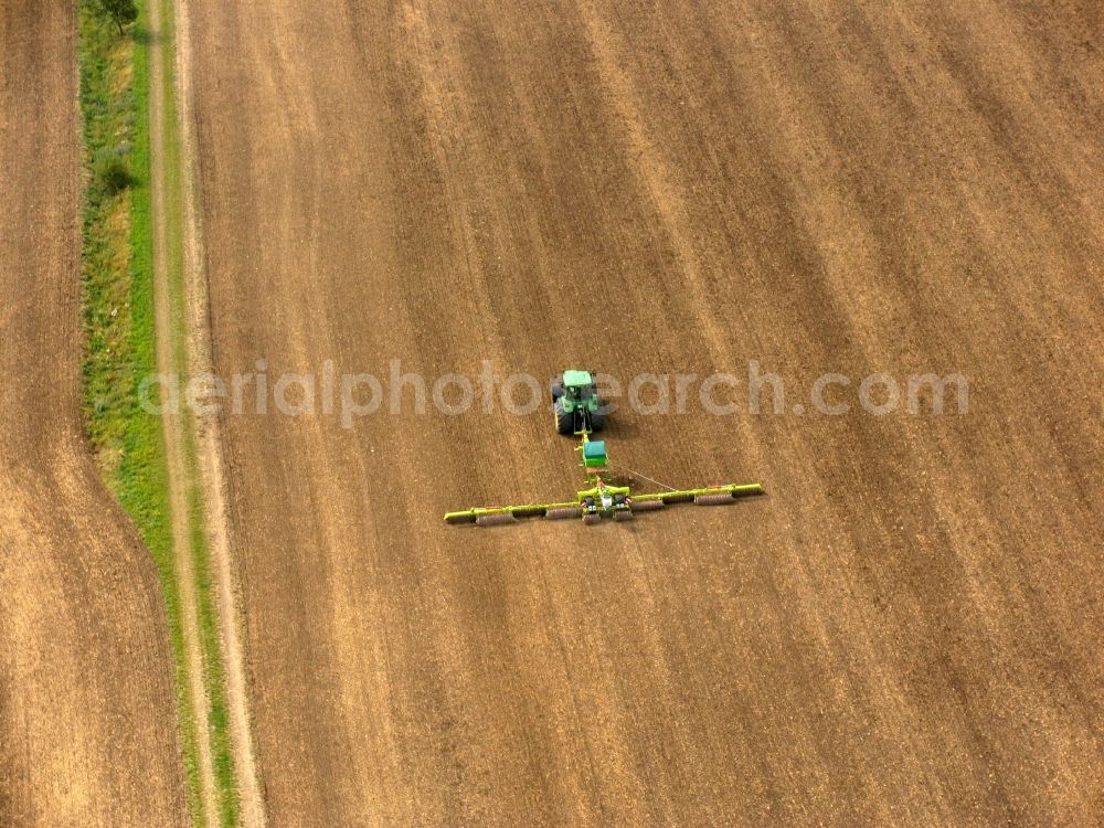 Alkersleben from the bird's eye view: Farm work with agricultural machinery on a grain field in Alkersleben in Thuringia