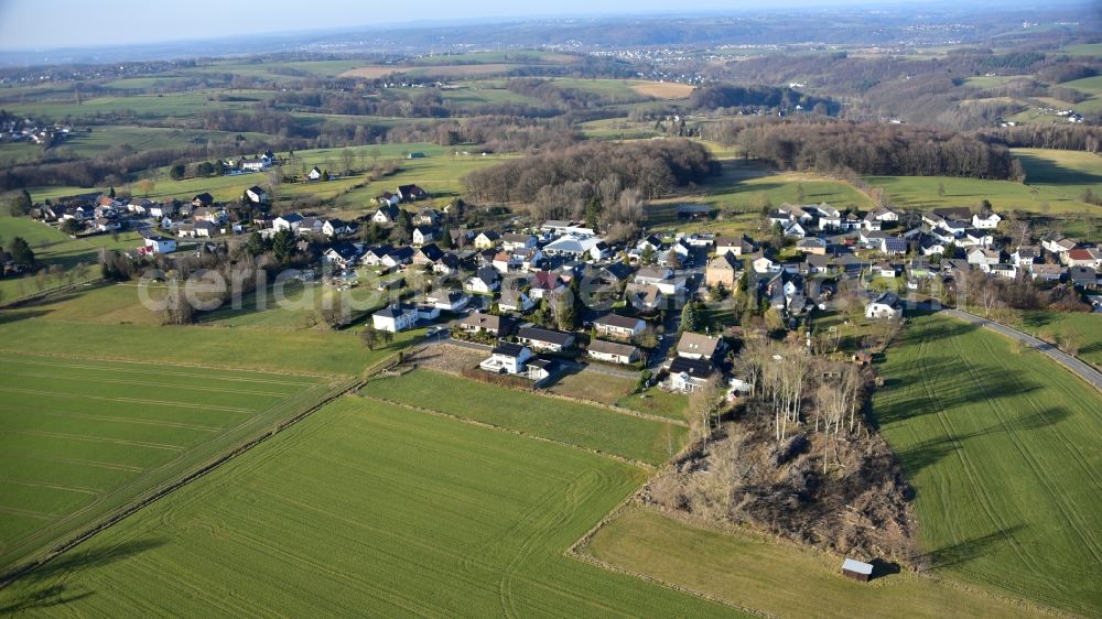 Hennef (Sieg) from the bird's eye view: Agricultural areas and field boundaries surround the settlement area of the village in Kurscheid in Hennef (Sieg) in the state North Rhine-Westphalia, Germany