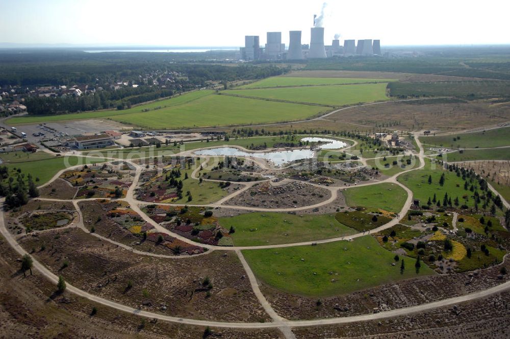 Boxberg from the bird's eye view: Der Lausitzer Findlingspark Nochten ist ein etwa 17 Hektar großer, im Jahr 2004 eröffneter Park in Ostsachsen. Er befindet sich bei Nochten, südwestlich von Weißwasser. Er entstand, als in den Jahren 2000 bis 2003 in einem rekultivierten Teil des Tagebaus Nochten über 3000 Findlinge aufgebaut wurden. Diese kamen während der Eiszeit aus Skandinavien im Eisschild mit und wurden über der Kohle der zukünftigen Tagebaue abgelagert. Im Hintergrund ist das Braunkohlekraftwerk Boxberg zu sehen. Verantwortlich für den Park ist der Förderverein Lausitzer Findlingspark Nochten e.V. Kontakt: Tel. +49(0)35774 55502, Email: info@lausitzer-findlingspark-nochten.com