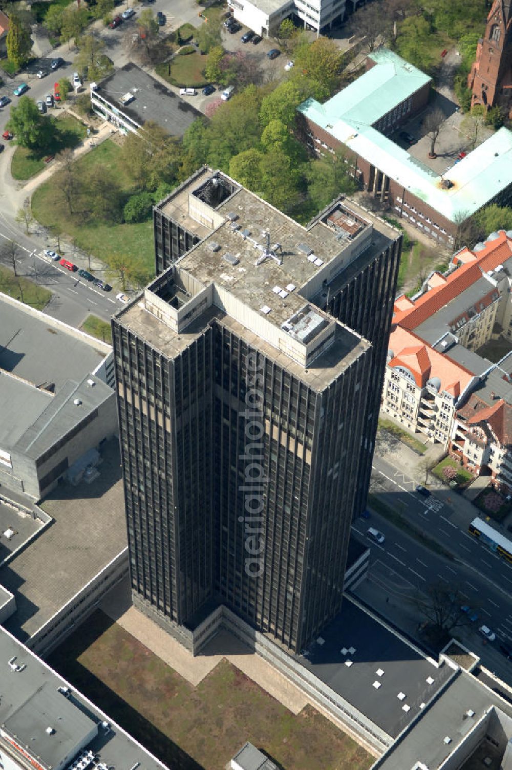 Aerial image Berlin - Blick auf den Steglitzer Kreisel , einen Gebäudekomplex mit Bürohochhaus im Berliner Ortsteil Steglitz. 2006 hatte der Berliner Senat beschlossen, das Bürohochhaus aufzugeben und die dort beschäftigten Mitarbeiter des Bezirksamts Steglitz-Zehlendorf in an deren landeseigenen Immobilien unterzubringen. 2007 wurde das Haus geräumt und steht derzeit leer. Die Berliner Finanzverwaltung und der Liegenschaftsfonds hatten vergeblich versucht, das Gebäude im jetzigen Zustand zu verkaufen. Die weitere Nutzung ist ungeklärt, neben dem Verkauf an Wolfgang Gerbere Investoren wird auch ein Abriss nicht ausgeschlossen. View of the Steglitzer Tops, a complex of office tower at the Berlin district of Steglitz.