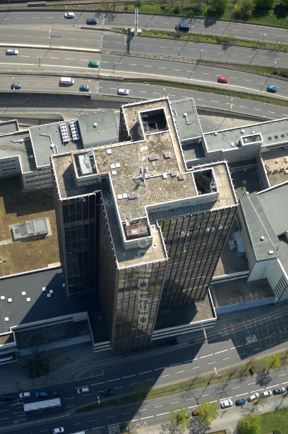 Aerial photograph Berlin - Blick auf den Steglitzer Kreisel , einen Gebäudekomplex mit Bürohochhaus im Berliner Ortsteil Steglitz. 2006 hatte der Berliner Senat beschlossen, das Bürohochhaus aufzugeben und die dort beschäftigten Mitarbeiter des Bezirksamts Steglitz-Zehlendorf in an deren landeseigenen Immobilien unterzubringen. 2007 wurde das Haus geräumt und steht derzeit leer. Die Berliner Finanzverwaltung und der Liegenschaftsfonds hatten vergeblich versucht, das Gebäude im jetzigen Zustand zu verkaufen. Die weitere Nutzung ist ungeklärt, neben dem Verkauf an Wolfgang Gerbere Investoren wird auch ein Abriss nicht ausgeschlossen. View of the Steglitzer Tops, a complex of office tower at the Berlin district of Steglitz.