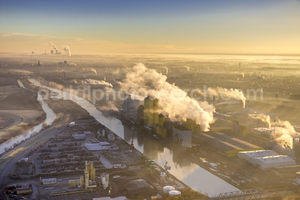 Hamm from the bird's eye view: Oil mill situated on the Datteln-Hamm-Kanal near the harbor in Hamm in the state North Rhine-Westphalia. Around the industrial area lies fog which is illuminated by the winter sunrise