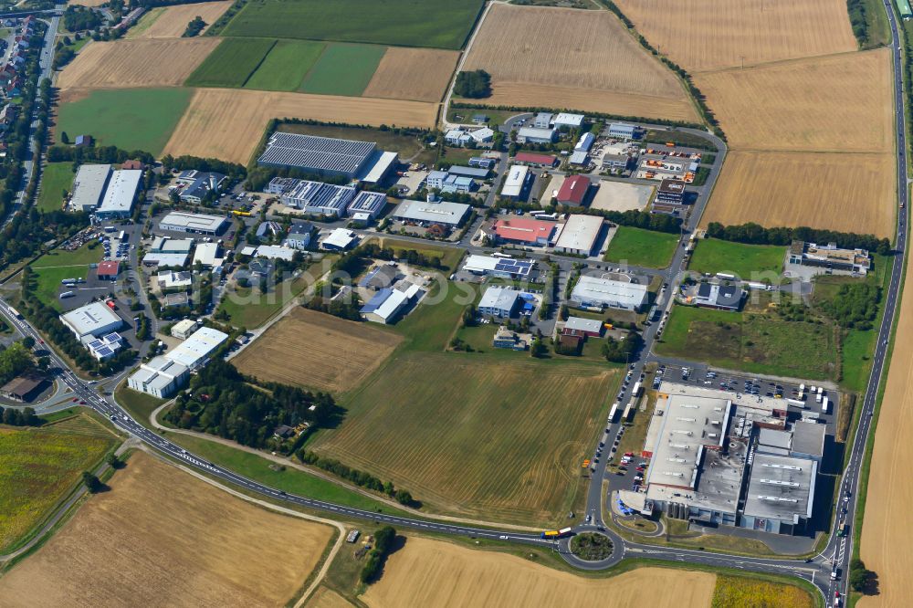 Aerial photograph Waldbüttelbrunn - Industrial and commercial area on the edge of agricultural fields and fields in Waldbüttelbrunn in the state Bavaria, Germany