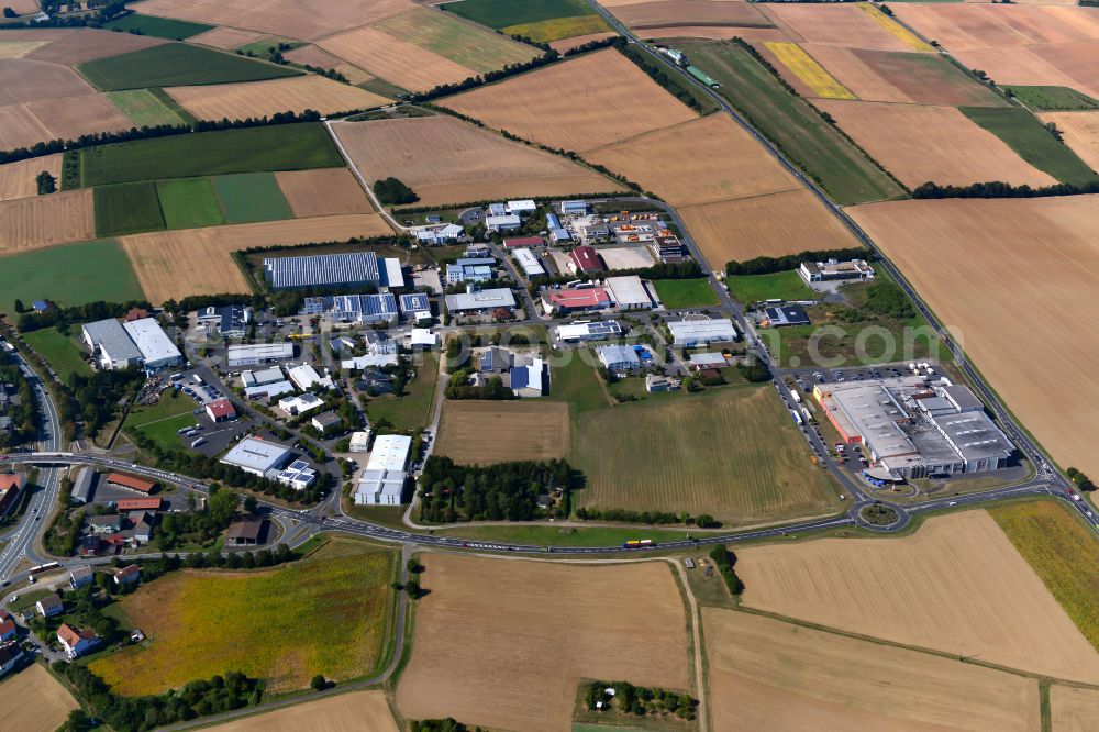 Waldbüttelbrunn from the bird's eye view: Industrial and commercial area on the edge of agricultural fields and fields in Waldbüttelbrunn in the state Bavaria, Germany