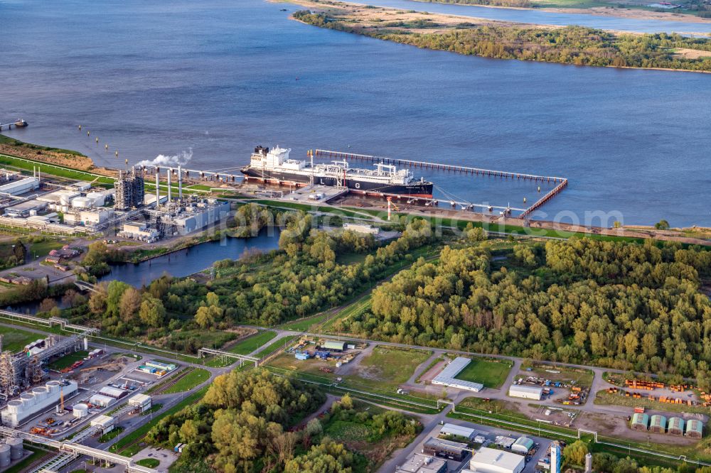 Aerial photograph Stade - Water bridge with pipeline systems of the LNG natural gas and liquid gas terminal and unloading quay with the special ship Energos Force (formerly Transgas Force) docking on the banks of the Elbe in the district of Buetzfleth in Stade in the state Lower Saxony, Germany