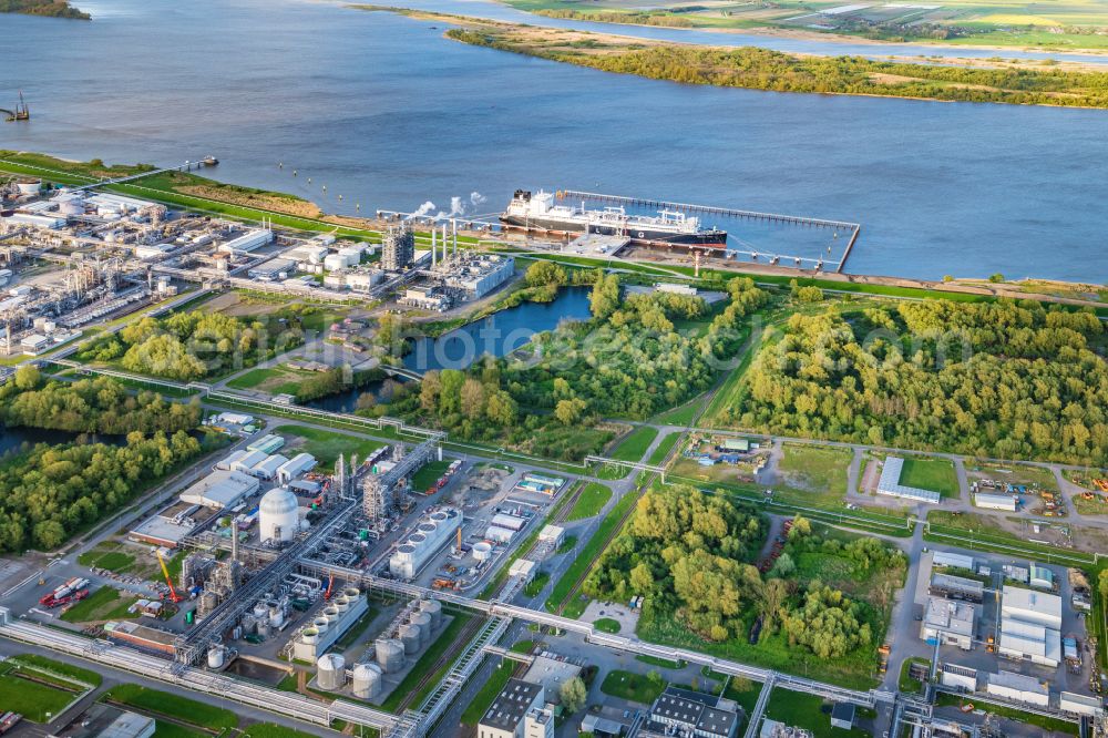 Stade from above - Water bridge with pipeline systems of the LNG natural gas and liquid gas terminal and unloading quay with the special ship Energos Force (formerly Transgas Force) docking on the banks of the Elbe in the district of Buetzfleth in Stade in the state Lower Saxony, Germany