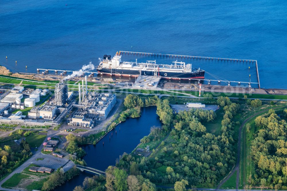 Aerial image Stade - Water bridge with pipeline systems of the LNG natural gas and liquid gas terminal and unloading quay with the special ship Energos Force (formerly Transgas Force) docking on the banks of the Elbe in the district of Buetzfleth in Stade in the state Lower Saxony, Germany