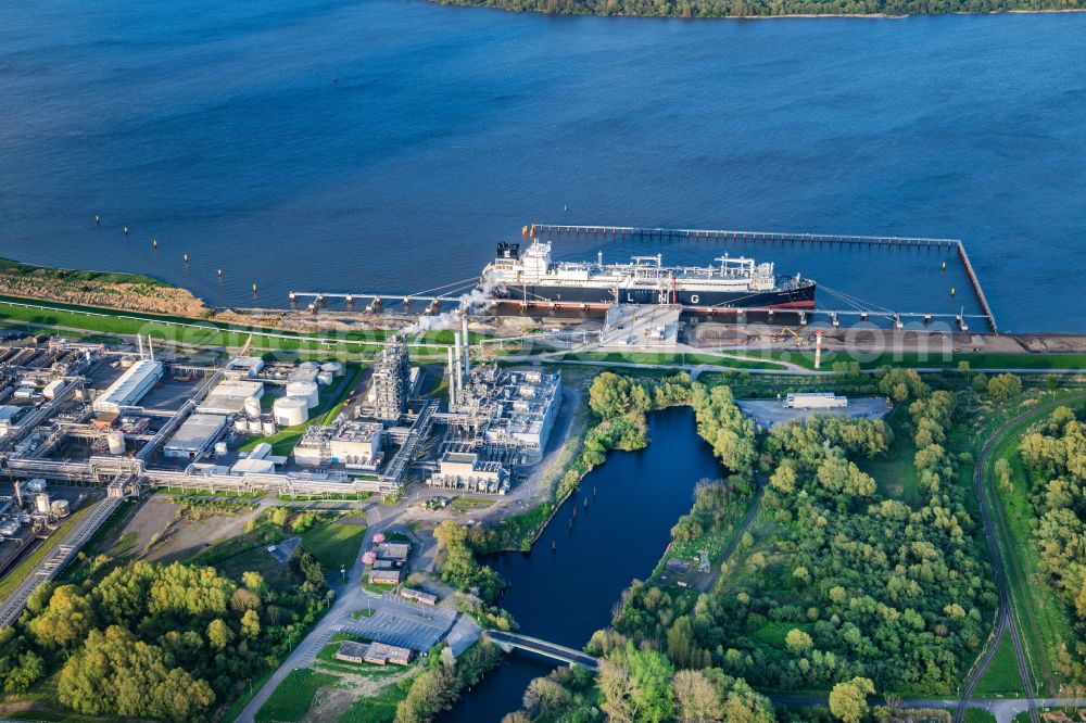 Aerial photograph Stade - Water bridge with pipeline systems of the LNG natural gas and liquid gas terminal and unloading quay with the special ship Energos Force (formerly Transgas Force) docking on the banks of the Elbe in the district of Buetzfleth in Stade in the state Lower Saxony, Germany