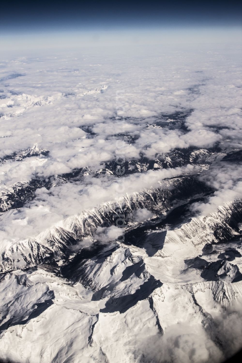 Locarno from the bird's eye view: Luftaufnahme aus 10.000 Meter Höhe vom schneebedeckten Gebirge der Alpen in Locarno in der Schweiz. / Aerial view from 10,000 meters from snow-capped mountains of the Alps in Locarno, Switzerland.