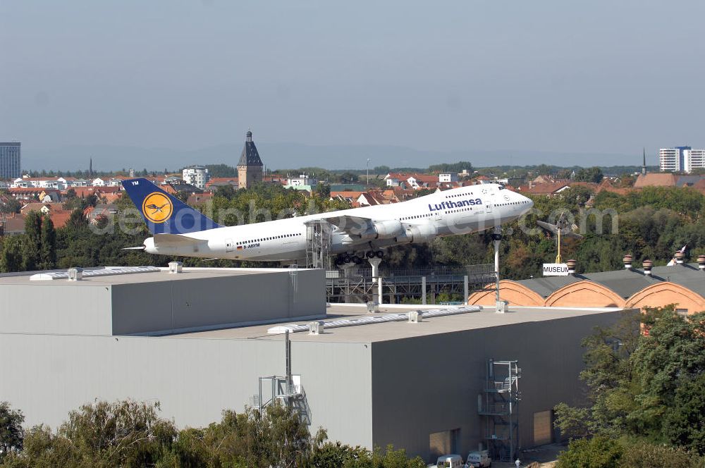 SPEYER from the bird's eye view: Blick auf die LUFTHANSA BOEING 747 auf dem Gelände des Technik-Museum Speyer. Es befindet sich in der Nähe des Speyerer Stadtzentrums am Flugplatz Speyer. Es präsentiert auf einer Hallenfläche von 15.000 m² und 100.000 m² Freigelände eine große Anzahl zum Teil besonderer technischer Konstruktionen aus dem Fahrzeug- und Flugzeugbau. Des Weiteren befinden sich auf dem Museumsgelände das so genannte Marinehaus und ein Modellbaumuseum sowie ein IMAX-Dome-Filmtheater mit einer 24 m durchmessenden kuppelförmigen Leinwand (Projektionsfläche ca. 1000 m²). Im Forum des Museums können sich Besucher kostenlos über die Transporte einiger größerer Ausstellungsobjekte zum Technik-Museum Speyer und zum Auto- und Technikmuseum Sinsheim informieren. Das Hauptgebäude, die denkmalgeschützte, riesige Liller Halle, war früher der Bahnhof der französischen Stadt Lille. 1915 nach Deutschland transportiert, diente sie als Produktionshalle für die Pfalz-Flugzeugwerke und später mehrere Jahrzehnte als Panzerhalle für die Aufklärungspanzer eines französischen leichten Panzeraufklärungsregiments, dem traditionsreichen letzten Spahi-Regiment 1er Spahis. Dieses nutzte bis 1984 das heutige Museumsgelände als Kaserne.