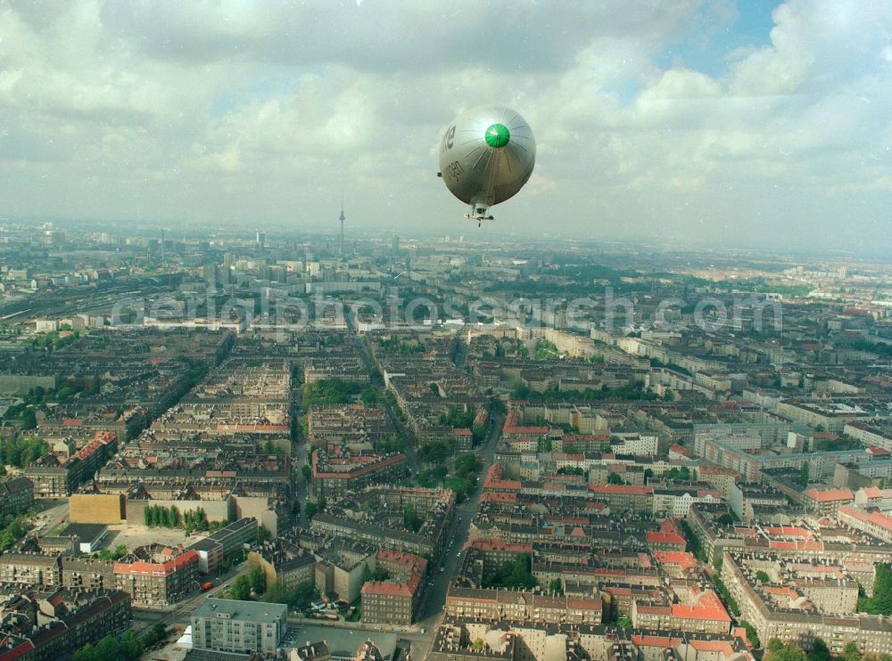 Aerial photograph Berlin - Blimp / zeppelin with the promotional material of the United Insurance above the city district of Berlin-Friedrichshain. Here overlooking the old building adjacent residential areas on the Modersohn street