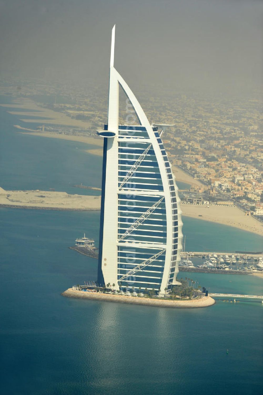 Aerial image DUBAI / DUBAYY - Blick auf das Luxus- Hotel Burj al Arab am Persischen Golf in Dubai. Der architektonisch einprägsame Bau der Jumeirah Group ist eines der luxuriösesten und teuersten Hotels der Welt. Mit einer Höhe von 321 Metern ist es nach dem Rose Tower das höchste reine Hotelgebäude der Welt und ein Wahrzeichen der emiratischen Stadt Dubai. Der Entwurf stammt von Tom Wright / Atkins Middle East. Ausdrücklicher Wunsch der Bauherren war es, eine Architekturikone zu schaffen, die ein Identifikationsmerkmal für Dubai wird. Der Entwurf hat die Form des Segels einer modernen Yacht und soll die Vergangenheit als Seehandelszentrum sowie die Zukunftsorientierung Dubais symbolisieren. Luxury hotel Burj al Arab on Persian Gulf in Dubai.