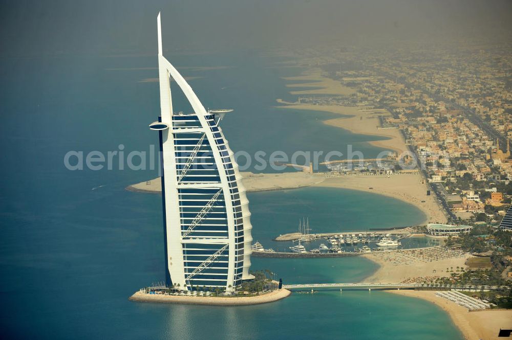 Aerial image DUBAI / DUBAYY - Blick auf das Luxus- Hotel Burj al Arab am Persischen Golf in Dubai. Der architektonisch einprägsame Bau der Jumeirah Group ist eines der luxuriösesten und teuersten Hotels der Welt. Mit einer Höhe von 321 Metern ist es nach dem Rose Tower das höchste reine Hotelgebäude der Welt und ein Wahrzeichen der emiratischen Stadt Dubai. Der Entwurf stammt von Tom Wright / Atkins Middle East. Ausdrücklicher Wunsch der Bauherren war es, eine Architekturikone zu schaffen, die ein Identifikationsmerkmal für Dubai wird. Der Entwurf hat die Form des Segels einer modernen Yacht und soll die Vergangenheit als Seehandelszentrum sowie die Zukunftsorientierung Dubais symbolisieren. Luxury hotel Burj al Arab on Persian Gulf in Dubai.