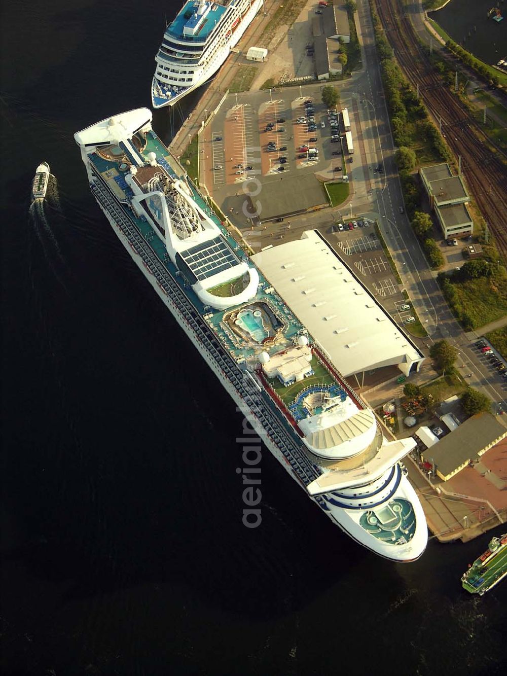 Aerial photograph Rostock - Warnemünde - Blick auf das Cruise Center an dem Luxusliner vor Anker liegen.Mit rund 100 Anläufen von knapp 30 Kreuzfahrtschiffen und mehr als 100.000 Passagieren pro Jahr zählt Rostock-Warnemünde zu den bedeutendsten Kreuzfahrthäfen Deutschlands. Hafen-Entwicklungsgesellschaft Rostock mbH, Ost-West-Str. 32; D - 18147 Rostock; +49 (0) 381 350 0; +49 (0) 381 350 5515; info@rostock-port.de