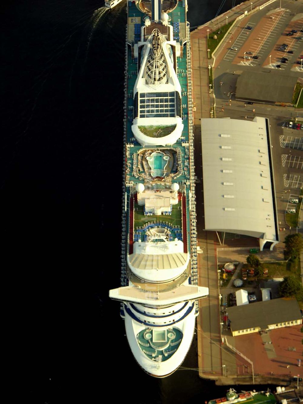 Rostock - Warnemünde from above - Blick auf das Cruise Center an dem Luxusliner vor Anker liegen.Mit rund 100 Anläufen von knapp 30 Kreuzfahrtschiffen und mehr als 100.000 Passagieren pro Jahr zählt Rostock-Warnemünde zu den bedeutendsten Kreuzfahrthäfen Deutschlands. Hafen-Entwicklungsgesellschaft Rostock mbH, Ost-West-Str. 32; D - 18147 Rostock; +49 (0) 381 350 0; +49 (0) 381 350 5515; info@rostock-port.de