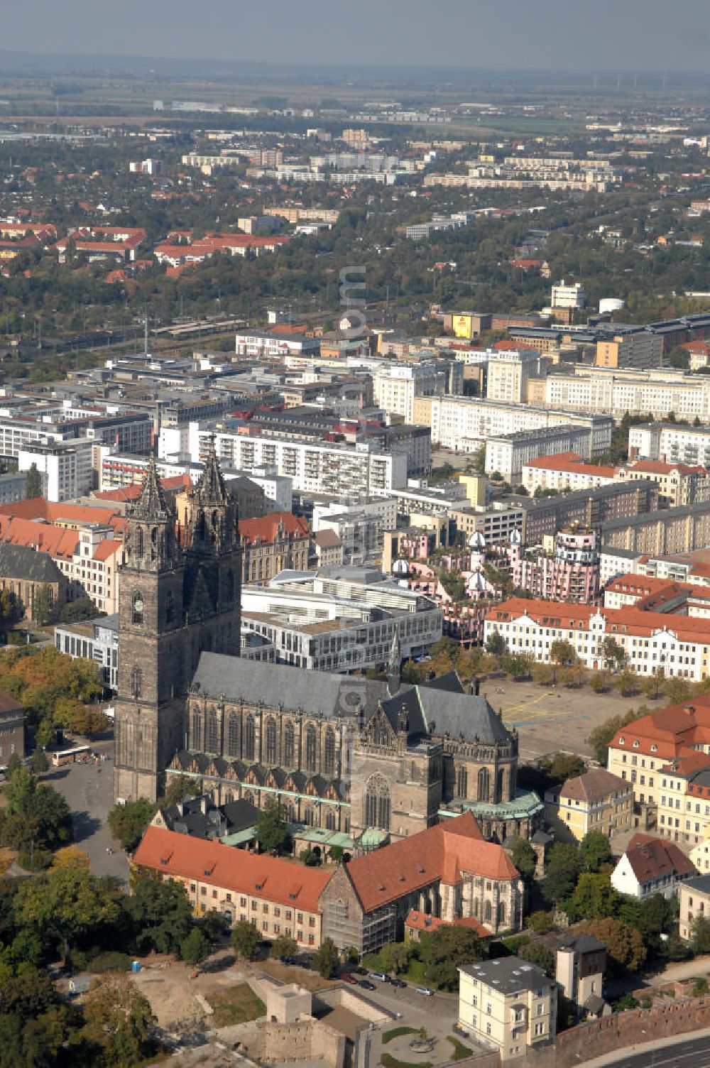 Magdeburg from above - Blick auf den Magdeburger Dom mit der Grünen Zitadelle im Hintergrund. Der evangelische Dom St. Katharina und St. Mauritius ist der ältesten gotischen Bauwerke Deutschlands. Von den 10 bis 15 mittelalterlichen Glocken des Domes sind heute noch fünf erhalten, deren drei großen eines der schwersten und größten Barockgeläute Deutschlands bilden. Und Obwohl der Dom mehrmals geplündert und fast zerstört wurde, birgt er viele Kunstschätze. Adresse: Evangelische Domgemeinde, Am Dom 1, 39104 Magdeburg Tel.: +49(0)391 5410436