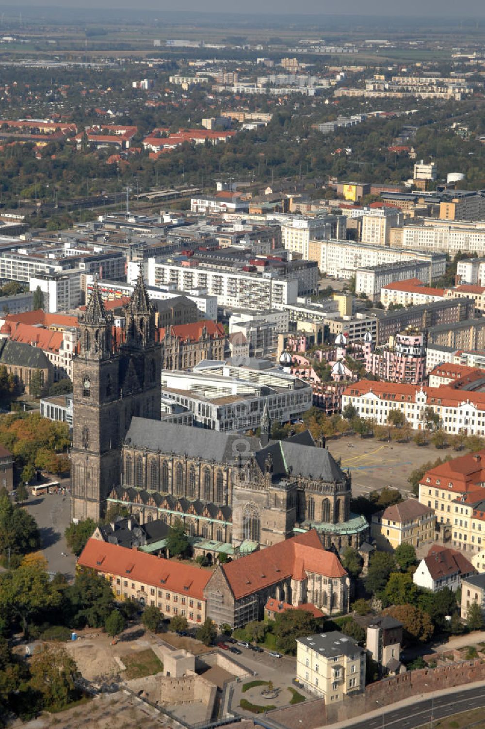 Magdeburg from the bird's eye view: Blick auf den Magdeburger Dom mit der Grünen Zitadelle im Hintergrund. Der evangelische Dom St. Katharina und St. Mauritius ist der ältesten gotischen Bauwerke Deutschlands. Von den 10 bis 15 mittelalterlichen Glocken des Domes sind heute noch fünf erhalten, deren drei großen eines der schwersten und größten Barockgeläute Deutschlands bilden. Und Obwohl der Dom mehrmals geplündert und fast zerstört wurde, birgt er viele Kunstschätze. Adresse: Evangelische Domgemeinde, Am Dom 1, 39104 Magdeburg Tel.: +49(0)391 5410436