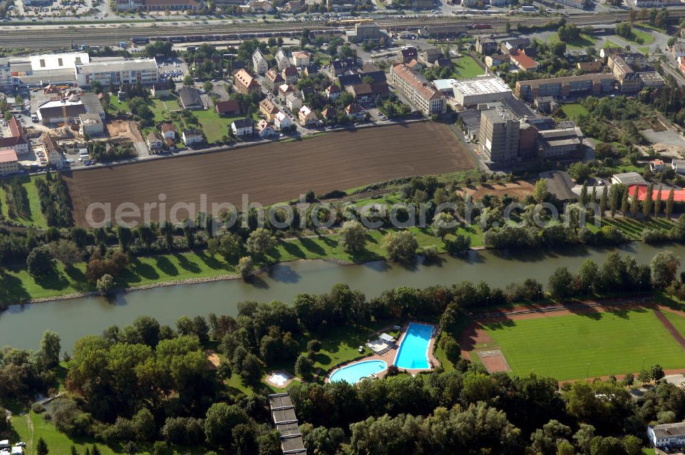 Aerial image Ochsenfurt - Blick aus Norden über den Uferbereich mit Sportstätte und Freibad auf der Maininsel am Main auf das Industriegebiet Ochsenfurt.