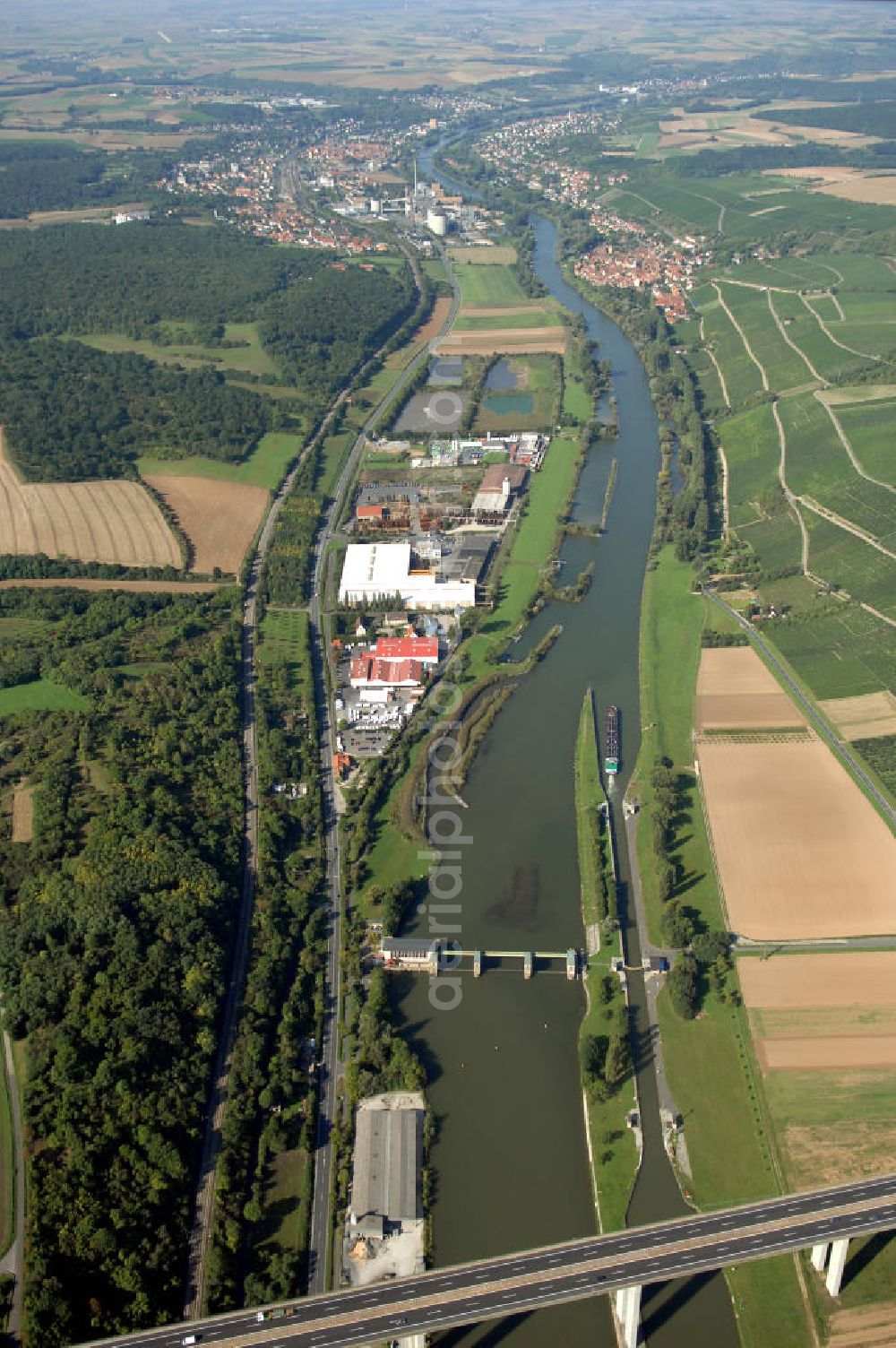 Aerial image Marktbreit - Blick aus Osten über die Schleuse, die Autobahnbrücke der A7 und das Gewerbegebiet Marktbreit auf den Flussverlauf des Main in Richtung Frickenhausen und Ochsenfurt.