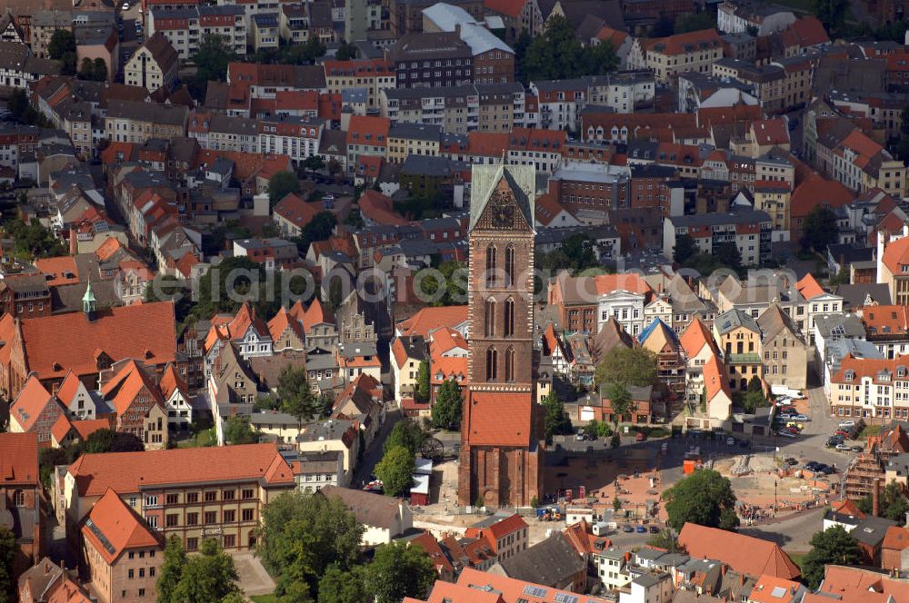 Aerial image Wismar - Blick auf die Marienkirche. Die Marienkirche (auch Sankt Marienkirche) im Zentrum der Altstadt Wismars ist die höchste der drei Stadtkirchen. Sie war Pfarrkirche der Marktstadt. Sie gehört zu den ältesten Bauwerken der Hansestadt. Ihr im Zweitem Weltkrieg schwer beschädigtes Schiff wurde 1960 gesprengt. 2009 wurden in mehreren Aktionen die Grundmauern über den alten Fundamenten des Kirchenschiffs symbolisch wiedererrichtet. Durch die Aktion, an der zahlreiche freiwillige Helfer teilnahmen, soll dem Wunsch Ausdruck verliehen werden, das Kirchenschiff wieder aufzubauen. Initiator ist der Förderverein St.-Marien-Kirche zu Wismar e.V. Informationen unter: