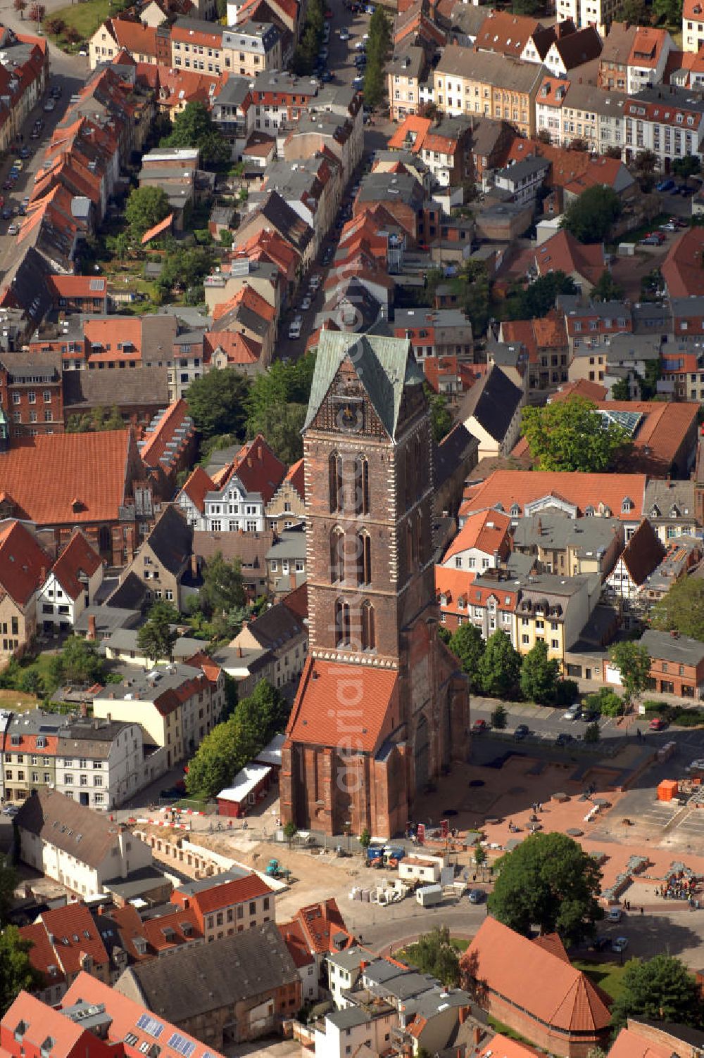 Aerial photograph Wismar - Blick auf die Marienkirche. Die Marienkirche (auch Sankt Marienkirche) im Zentrum der Altstadt Wismars ist die höchste der drei Stadtkirchen. Sie war Pfarrkirche der Marktstadt. Sie gehört zu den ältesten Bauwerken der Hansestadt. Ihr im Zweitem Weltkrieg schwer beschädigtes Schiff wurde 1960 gesprengt. 2009 wurden in mehreren Aktionen die Grundmauern über den alten Fundamenten des Kirchenschiffs symbolisch wiedererrichtet. Durch die Aktion, an der zahlreiche freiwillige Helfer teilnahmen, soll dem Wunsch Ausdruck verliehen werden, das Kirchenschiff wieder aufzubauen. Initiator ist der Förderverein St.-Marien-Kirche zu Wismar e.V. Informationen unter: