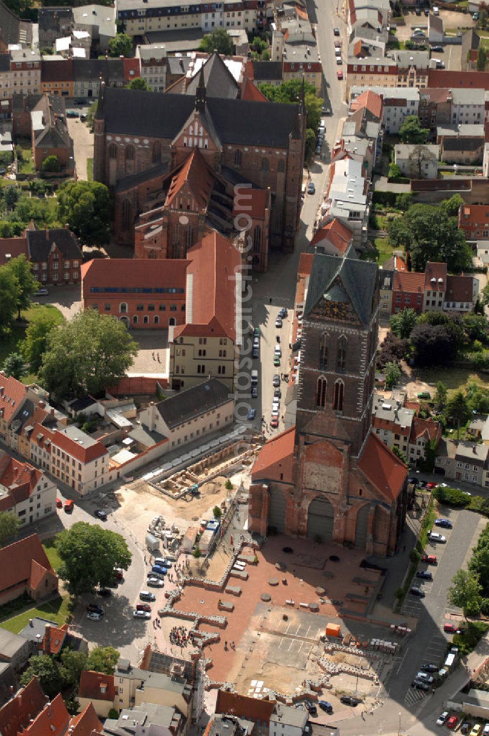 Wismar from the bird's eye view: Blick auf die Marienkirche. Die Marienkirche (auch Sankt Marienkirche) im Zentrum der Altstadt Wismars ist die höchste der drei Stadtkirchen. Sie war Pfarrkirche der Marktstadt. Sie gehört zu den ältesten Bauwerken der Hansestadt. Ihr im Zweitem Weltkrieg schwer beschädigtes Schiff wurde 1960 gesprengt. 2009 wurden in mehreren Aktionen die Grundmauern über den alten Fundamenten des Kirchenschiffs symbolisch wiedererrichtet. Durch die Aktion, an der zahlreiche freiwillige Helfer teilnahmen, soll dem Wunsch Ausdruck verliehen werden, das Kirchenschiff wieder aufzubauen. Initiator ist der Förderverein St.-Marien-Kirche zu Wismar e.V. Informationen unter: