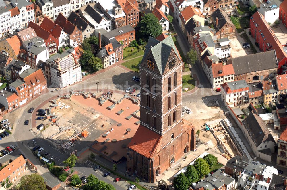 Aerial image Wismar - Blick auf die Marienkirche. Die Marienkirche (auch Sankt Marienkirche) im Zentrum der Altstadt Wismars ist die höchste der drei Stadtkirchen. Sie war Pfarrkirche der Marktstadt. Sie gehört zu den ältesten Bauwerken der Hansestadt. Ihr im Zweitem Weltkrieg schwer beschädigtes Schiff wurde 1960 gesprengt. 2009 wurden in mehreren Aktionen die Grundmauern über den alten Fundamenten des Kirchenschiffs symbolisch wiedererrichtet. Durch die Aktion, an der zahlreiche freiwillige Helfer teilnahmen, soll dem Wunsch Ausdruck verliehen werden, das Kirchenschiff wieder aufzubauen. Initiator ist der Förderverein St.-Marien-Kirche zu Wismar e.V. Informationen unter: