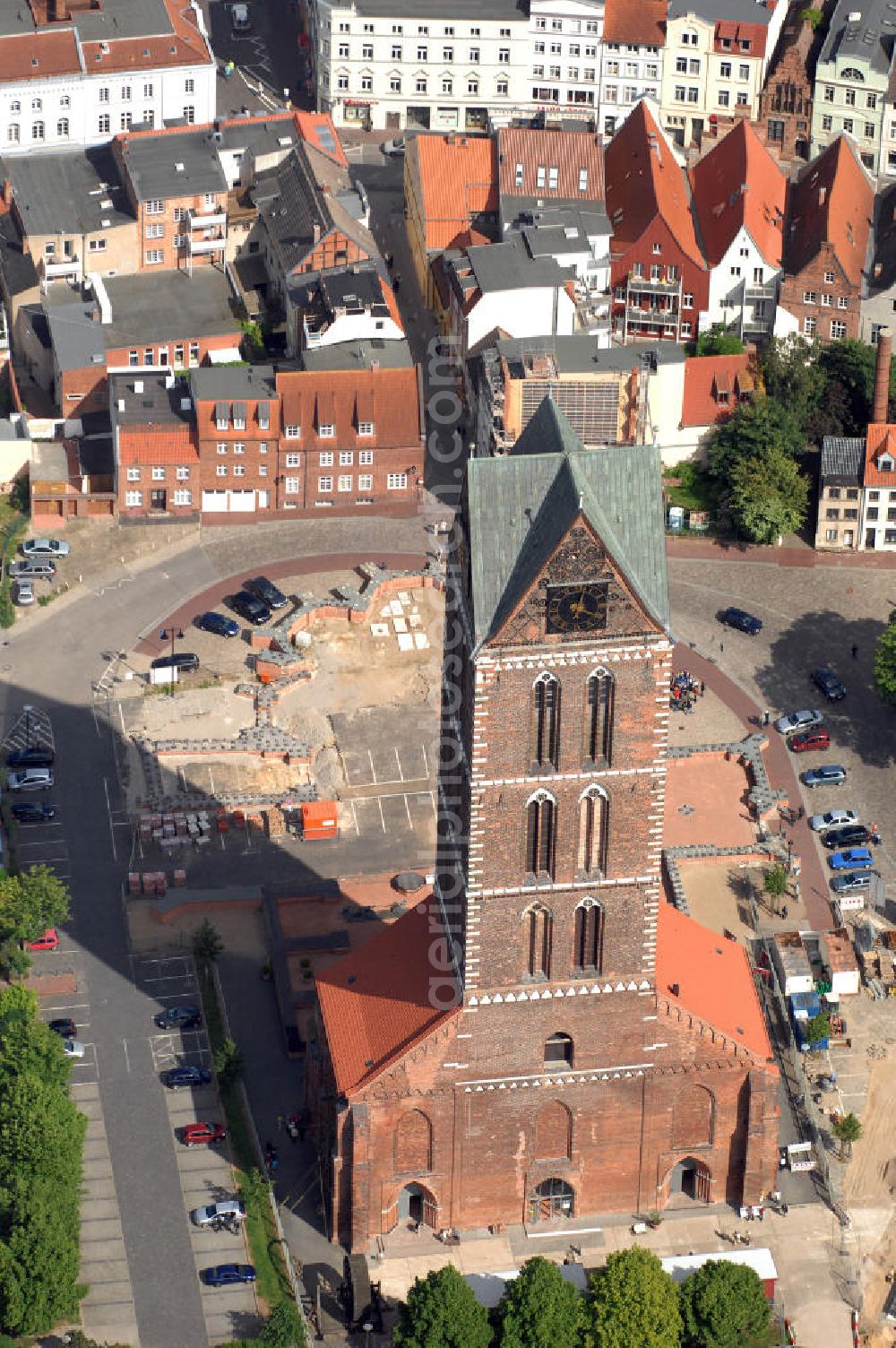 Aerial photograph Wismar - Blick auf die Marienkirche. Die Marienkirche (auch Sankt Marienkirche) im Zentrum der Altstadt Wismars ist die höchste der drei Stadtkirchen. Sie war Pfarrkirche der Marktstadt. Sie gehört zu den ältesten Bauwerken der Hansestadt. Ihr im Zweitem Weltkrieg schwer beschädigtes Schiff wurde 1960 gesprengt. 2009 wurden in mehreren Aktionen die Grundmauern über den alten Fundamenten des Kirchenschiffs symbolisch wiedererrichtet. Durch die Aktion, an der zahlreiche freiwillige Helfer teilnahmen, soll dem Wunsch Ausdruck verliehen werden, das Kirchenschiff wieder aufzubauen. Initiator ist der Förderverein St.-Marien-Kirche zu Wismar e.V. Informationen unter: