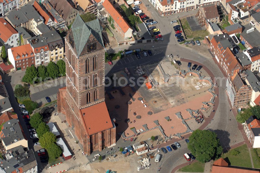 Aerial image Wismar - Blick auf die Marienkirche. Die Marienkirche (auch Sankt Marienkirche) im Zentrum der Altstadt Wismars ist die höchste der drei Stadtkirchen. Sie war Pfarrkirche der Marktstadt. Sie gehört zu den ältesten Bauwerken der Hansestadt. Ihr im Zweitem Weltkrieg schwer beschädigtes Schiff wurde 1960 gesprengt. 2009 wurden in mehreren Aktionen die Grundmauern über den alten Fundamenten des Kirchenschiffs symbolisch wiedererrichtet. Durch die Aktion, an der zahlreiche freiwillige Helfer teilnahmen, soll dem Wunsch Ausdruck verliehen werden, das Kirchenschiff wieder aufzubauen. Initiator ist der Förderverein St.-Marien-Kirche zu Wismar e.V. Informationen unter: