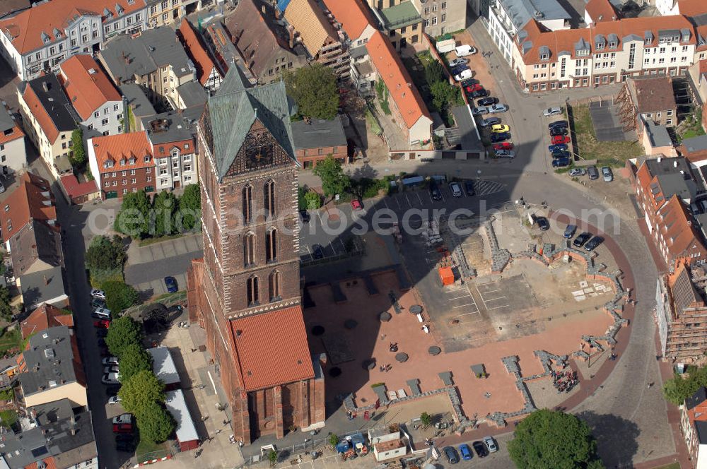 Aerial photograph Wismar - Blick auf die Marienkirche. Die Marienkirche (auch Sankt Marienkirche) im Zentrum der Altstadt Wismars ist die höchste der drei Stadtkirchen. Sie war Pfarrkirche der Marktstadt. Sie gehört zu den ältesten Bauwerken der Hansestadt. Ihr im Zweitem Weltkrieg schwer beschädigtes Schiff wurde 1960 gesprengt. 2009 wurden in mehreren Aktionen die Grundmauern über den alten Fundamenten des Kirchenschiffs symbolisch wiedererrichtet. Durch die Aktion, an der zahlreiche freiwillige Helfer teilnahmen, soll dem Wunsch Ausdruck verliehen werden, das Kirchenschiff wieder aufzubauen. Initiator ist der Förderverein St.-Marien-Kirche zu Wismar e.V. Informationen unter: