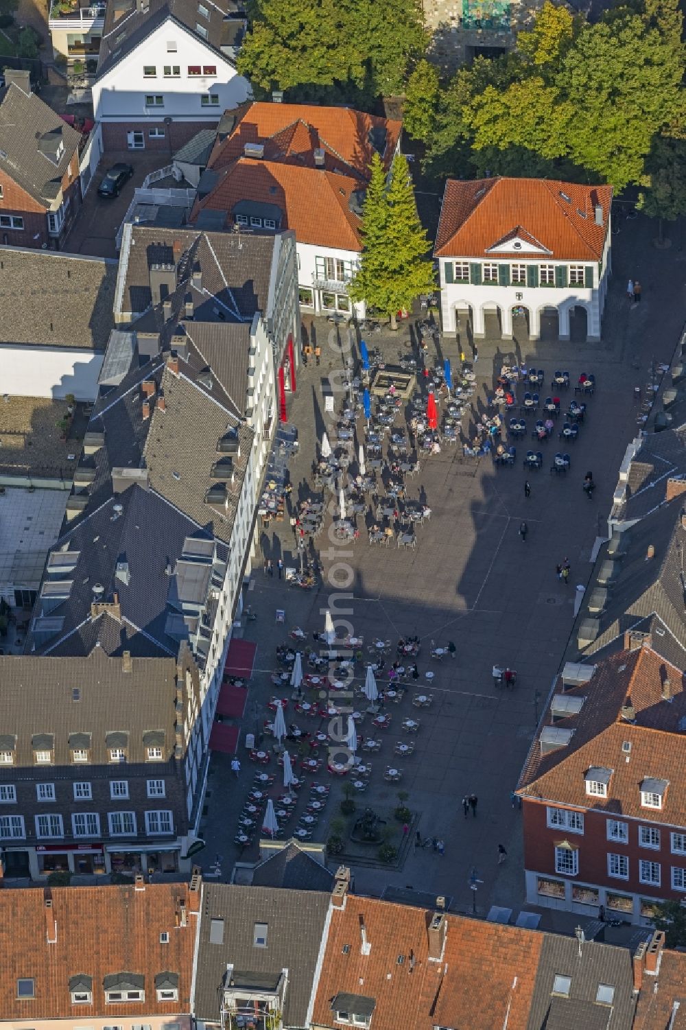 Dorsten from the bird's eye view: View at the market in Dorsten in the state North Rhine-Westphalia. On the marketplace stand tables, chairs and umbrellas of the Café Solo, which are casting shadows in the afternoon sun