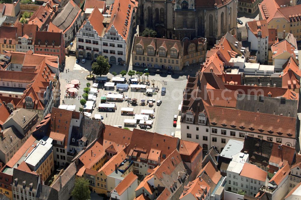 Aerial image Naumburg - Blick auf den Marktplatz von Naumburg mit der Stadtkirche St. Wenzel, auch Wenzelkirche genannt. Die evangelisch-lutherische Stadtkirche ist die Hauptkirche der Stadt außerhalb des geistlichen Bezirks der ehemaligen Domfreiheit. Als das markanteste Kirchenbauwerk und Wahrzeichen der Ratsstadt von Naumburg gehört die Wenzelskirche zu den bedeutsamsten Bauwerken an der Saale. Der spätgotische Bau von 1426 erhielt 1510/1520 sein Westportal und 1724 im Innern eine barocke Ausstattung. Der Kirchturm der evangelischen Wenzelskirche ist mit 72 Metern der höchste Turm der Stadt. Er besitzt in seiner Türmerwohnung in 53 Metern Höhe eine Aussichtsplattform, die von April bis Oktober täglich geöffnet hat.